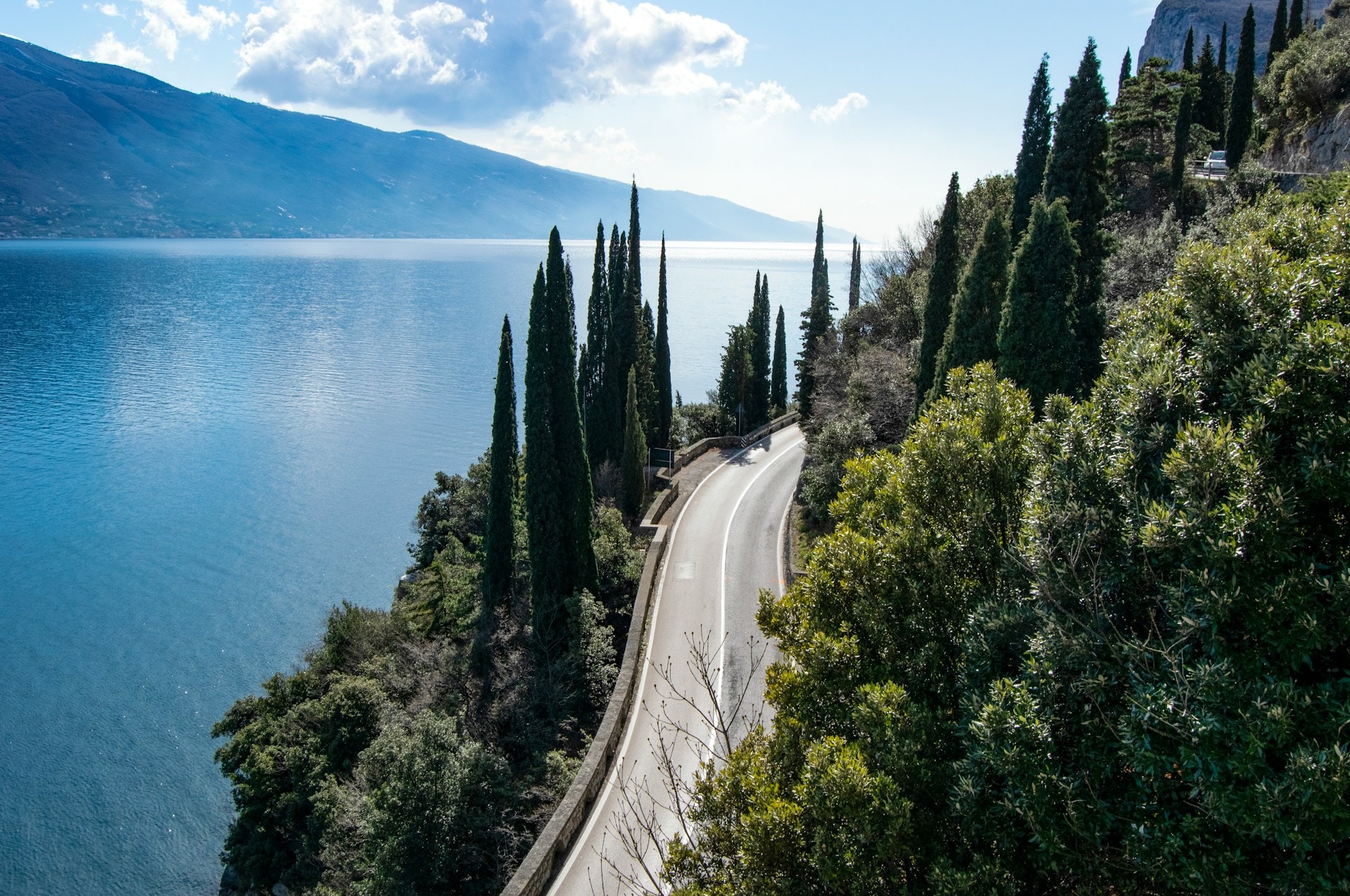 A narrow cliffside road with lake views below — Ponale Road above Riva del Garda, Lake Garda.